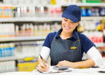 beautiful store clerk writing stock in supermarket