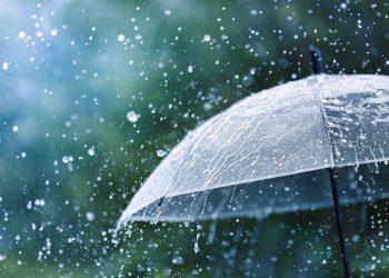 Transparent umbrella under rain against water drops splash background. Rainy weather concept.