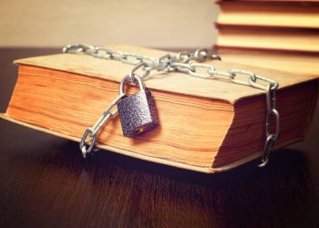 old book wrapped with chain and locked on padlock on table, concept, toned